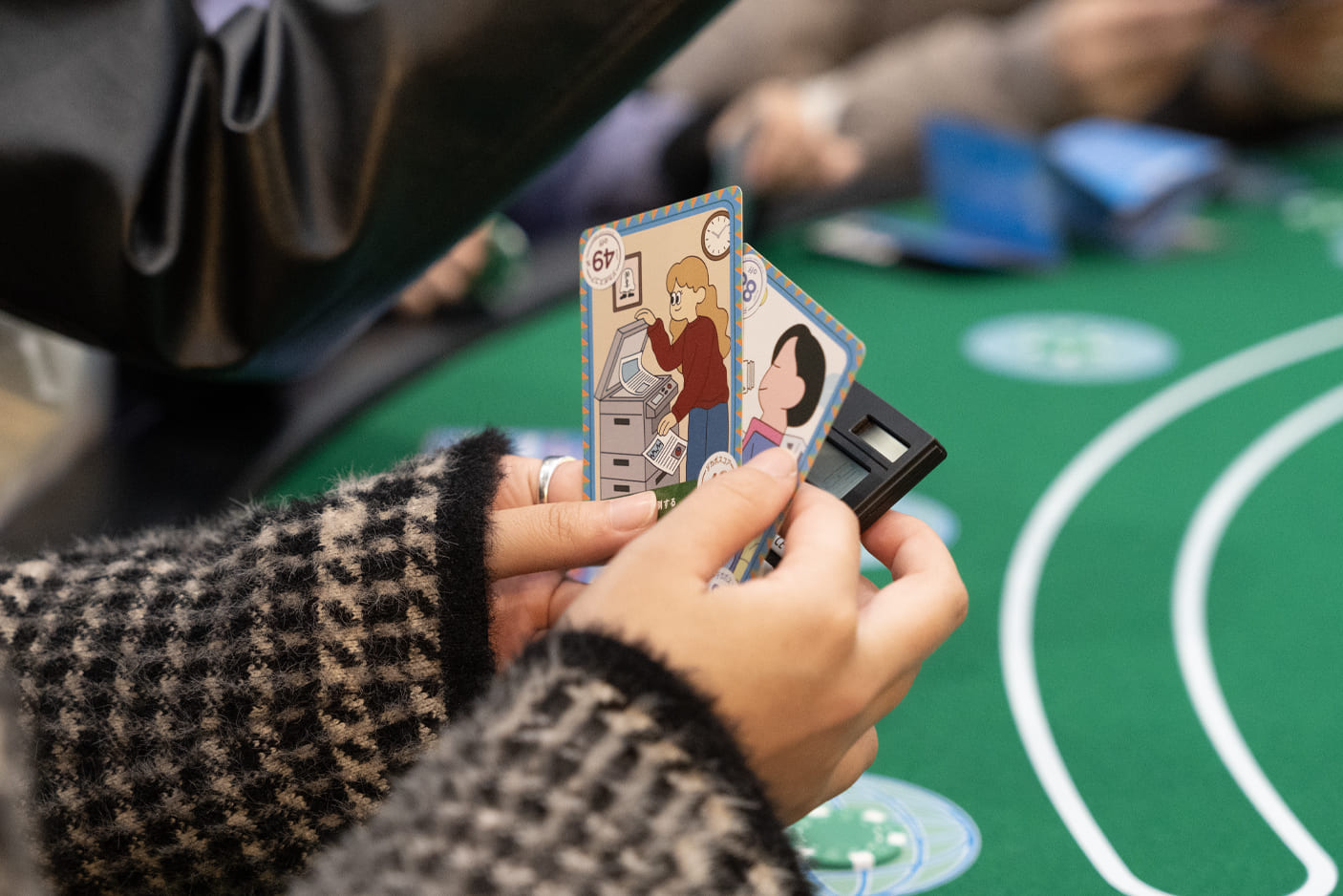 テーブル上でカードゲームをプレイしている手元の様子